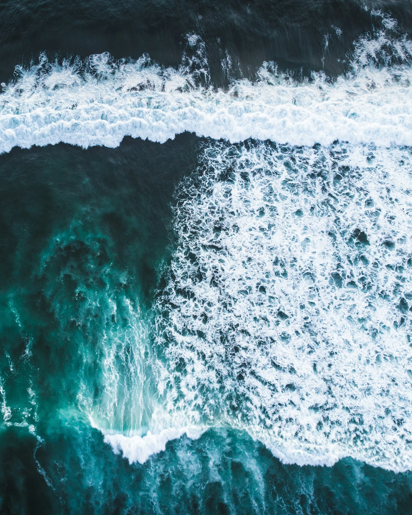 White Atlantic waves breaking across deep teal water off Ericeira, Portugal
