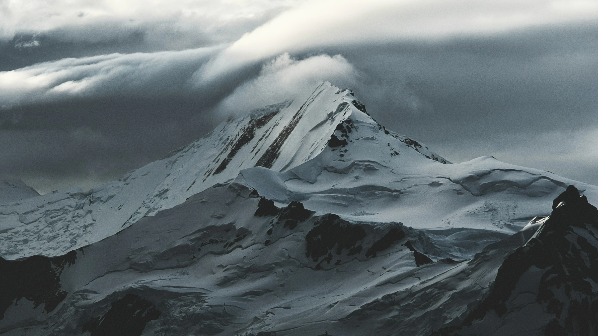 Clouds passing over a snow-covered mountain